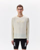 Person wearing a beige long-sleeve shirt and black shorts with 'UYN' branding on a white background