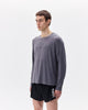 Person wearing a gray long-sleeve shirt and black shorts with 'UVA' branding on a white background